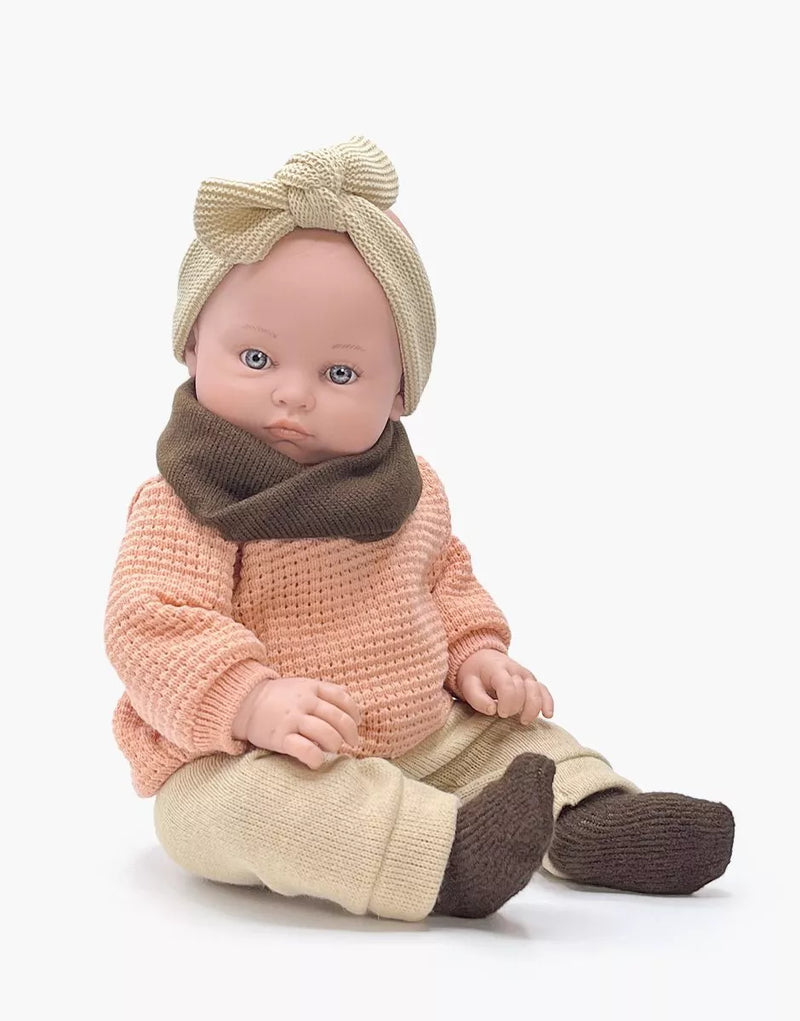 Yaëlle, a 47cm Bambinis doll dressed in her winter clothes with a pink knitted sweater